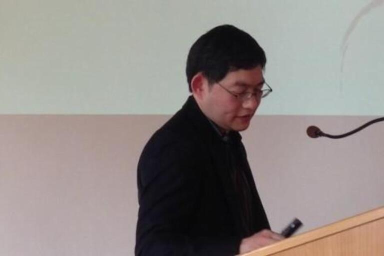 Pheng Cheah stands at a lectern giving a talk in Berlin