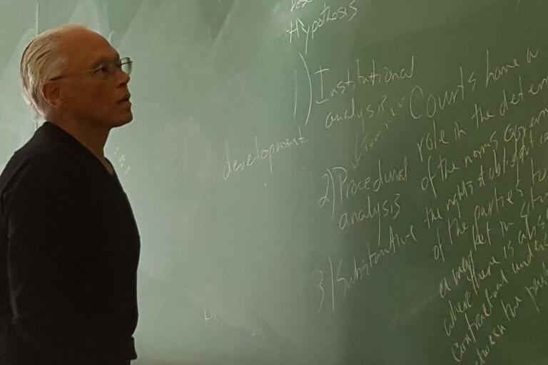 Felipe R. Gutterriez standing in front of a chalkboard teaching